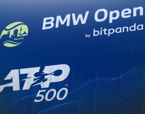 На изображении логотипы турнира BMW Open by Bitpanda и ATP 500 на синем фоне. Слева видно стилизованное изображение Мюнхена с надписью Munich