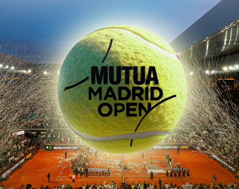 Теннисный мяч с логотипом Mutua Madrid Open на фоне стадиона с оранжевым грунтовым покрытием. Вокруг игроки, болельщики, конфетти и вечернее освещение. Турнирная атмосфера и празднование успеха